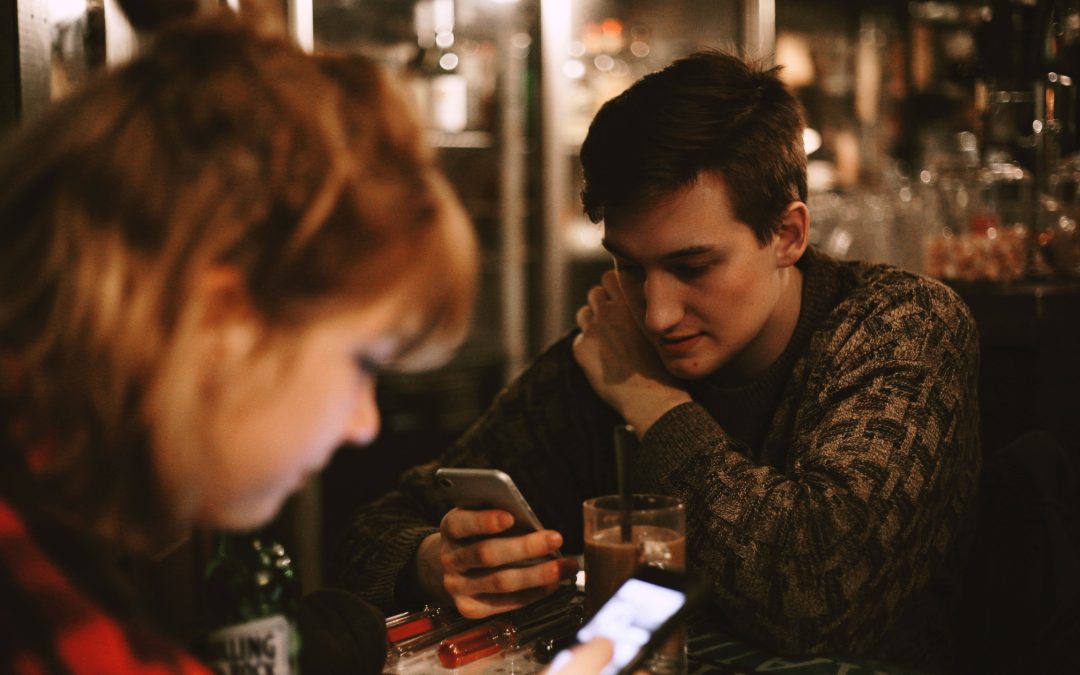 people on their mobile phones on a date